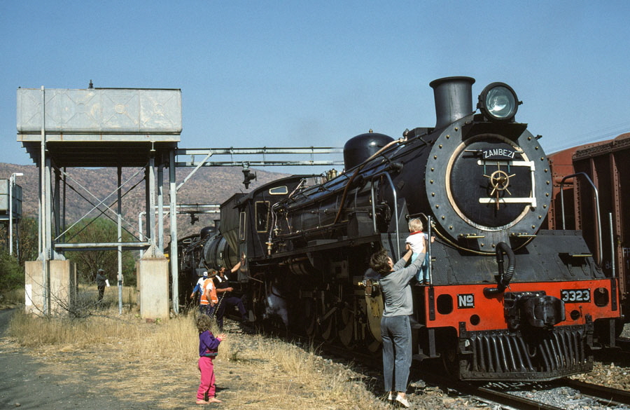 South African class 19D 4-8-2 steam locomotives being serviced with young enthusiasts at Waterpoort, South Africa