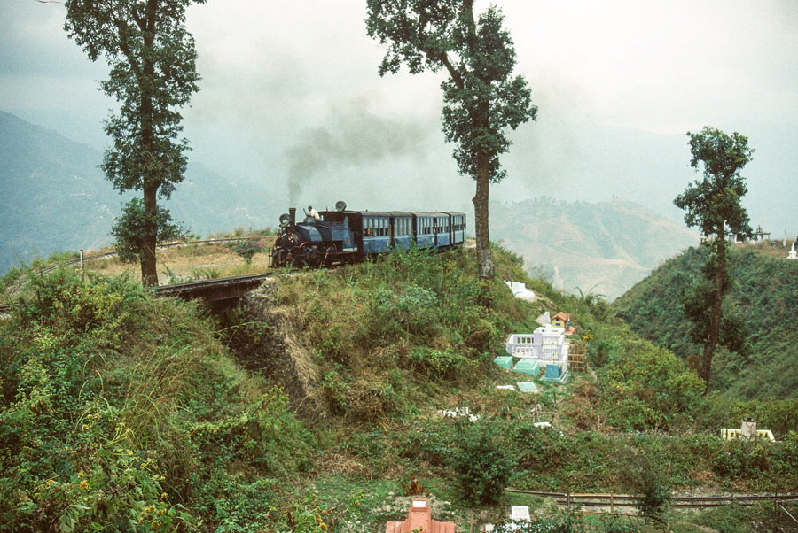 Darjeeling Himalayan Railway narrow gauge steam locomotive, class B 0-4-0ST no. 805 reverses to replace the engine on a passenger train traversing a loop while heading up the mountain to Darjeeling, India,