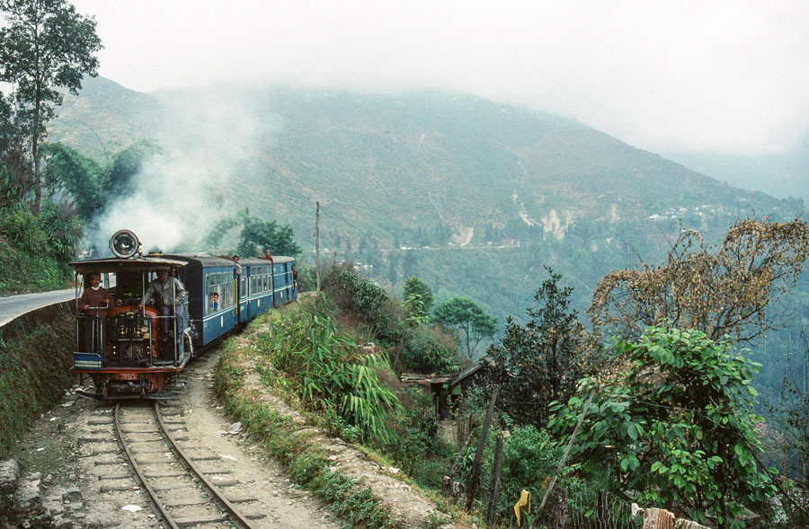 Darjeeling Himalayan Railway narrow gauge steam locomotive, class B 0-4-0ST no. 782 heads a passenger train down the mountain from Darjeeling, India,