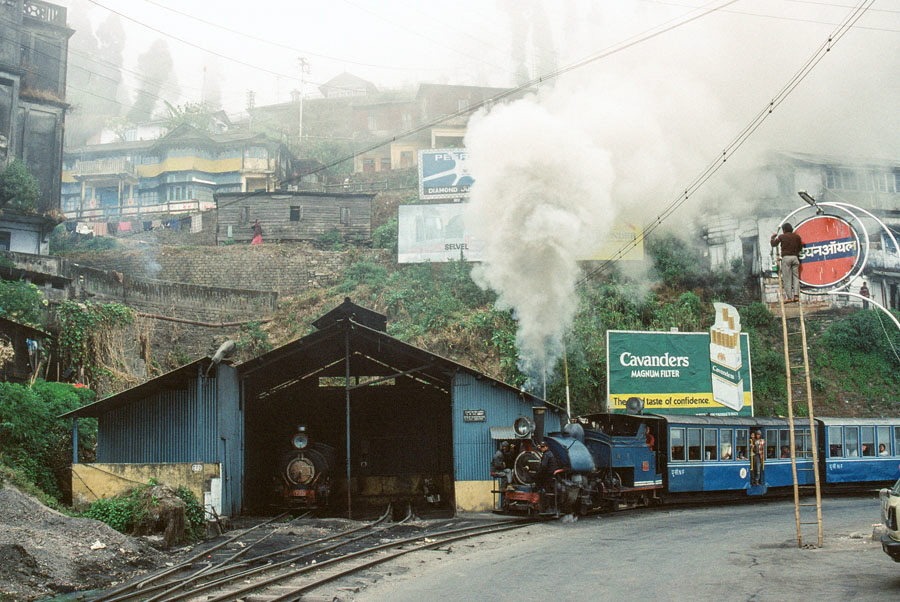 Darjeeling Himalayan Railway narrow gauge steam locomotive, class B 0-4-0ST no. 805 reverses to replace the engine on a passenger train enters Kurseong with a passenger train on election day while heading towards Darjeeling, India