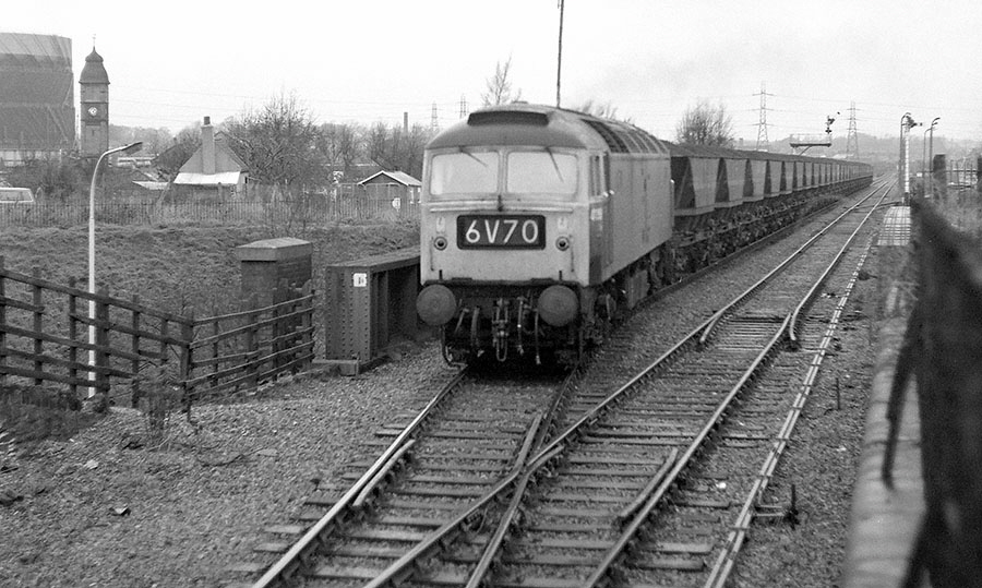 An unidentified class 47 Co-Co diesel locomotive crosses Saffron Lane bridge with a "Merry Go Round" coal train on the Burton to Leicester line,