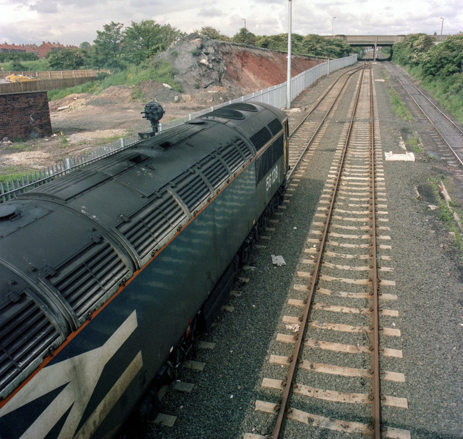 Class 56 Co-Co diesel locomotive no. 56128 stands at the front of a loaded coal train on the connection from British Rail to the incline from Seaham colliery