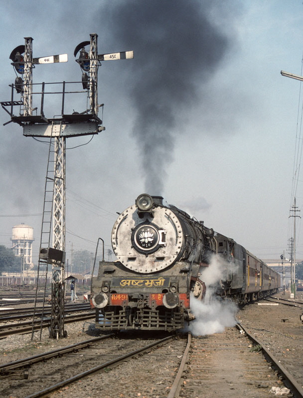 road gauge, class WG 2-8-2 10491 (built by Chittaranjan Loco Works in 1966/7), departs with a passenger train from Bareilly Junction station, India, 27th December 1993