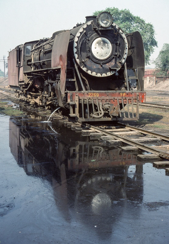 Metre gauge, steam locomotive class YP 4-6-2 2269, built by Krauss-Maffei in 1954, and its reflection at Bareilly City locomotive shed, India, 27th December 1993