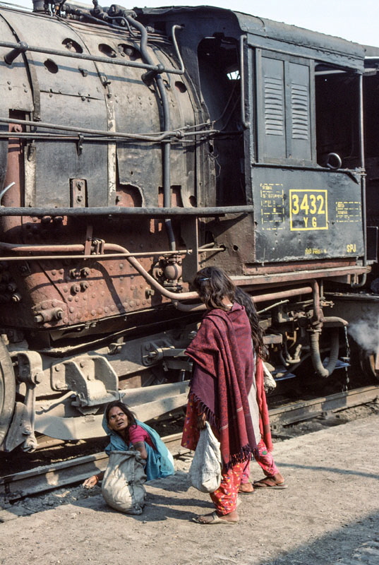 Women gathering bits of coal dropped from the ashpan of steam locomotive metre gauge class YG 2-8-2 at Samastipur Junction station, 29th December 1993